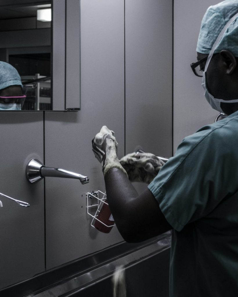 man wearing surgical suit near mirror